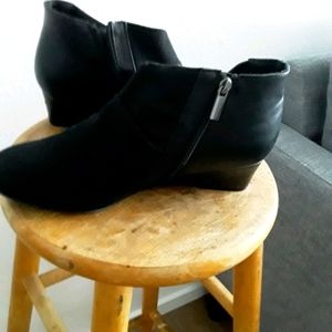 Women’s short booties are black with a zipper on the side